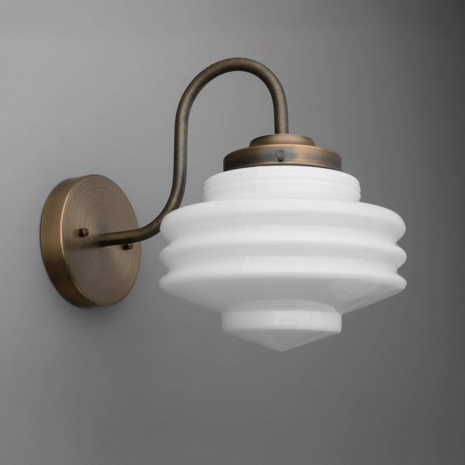 Antique bronze 1-bulb wall sconce with curved arm and layered white glass shade. - SCONCE MODEL NO. 1096