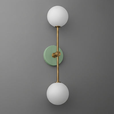 Modern raw brass double globe wall sconce with matte green circular backplate and frosted white glass shades. - SCONCE MODEL NO. 9776