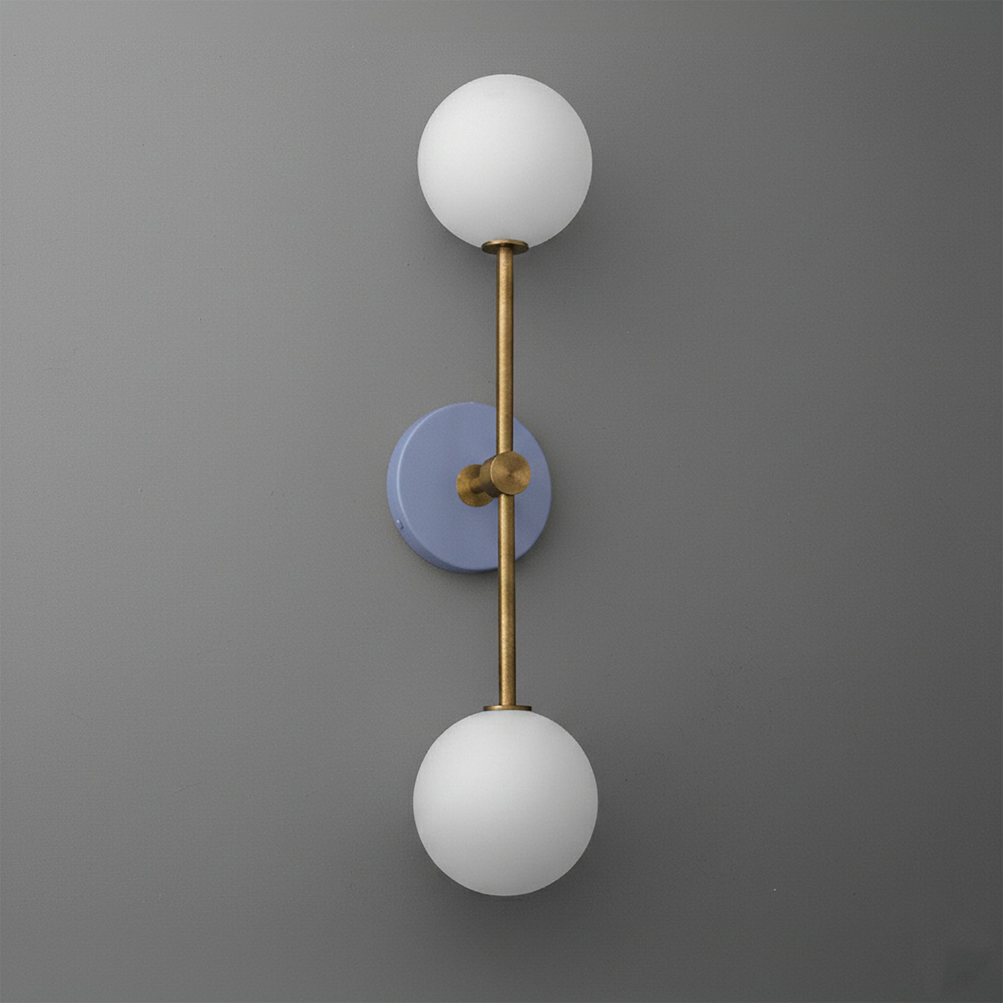 Wall sconce with raw brass finish and periwinkle circular backplate, featuring two white frosted glass globes. - SCONCE MODEL NO. 9776