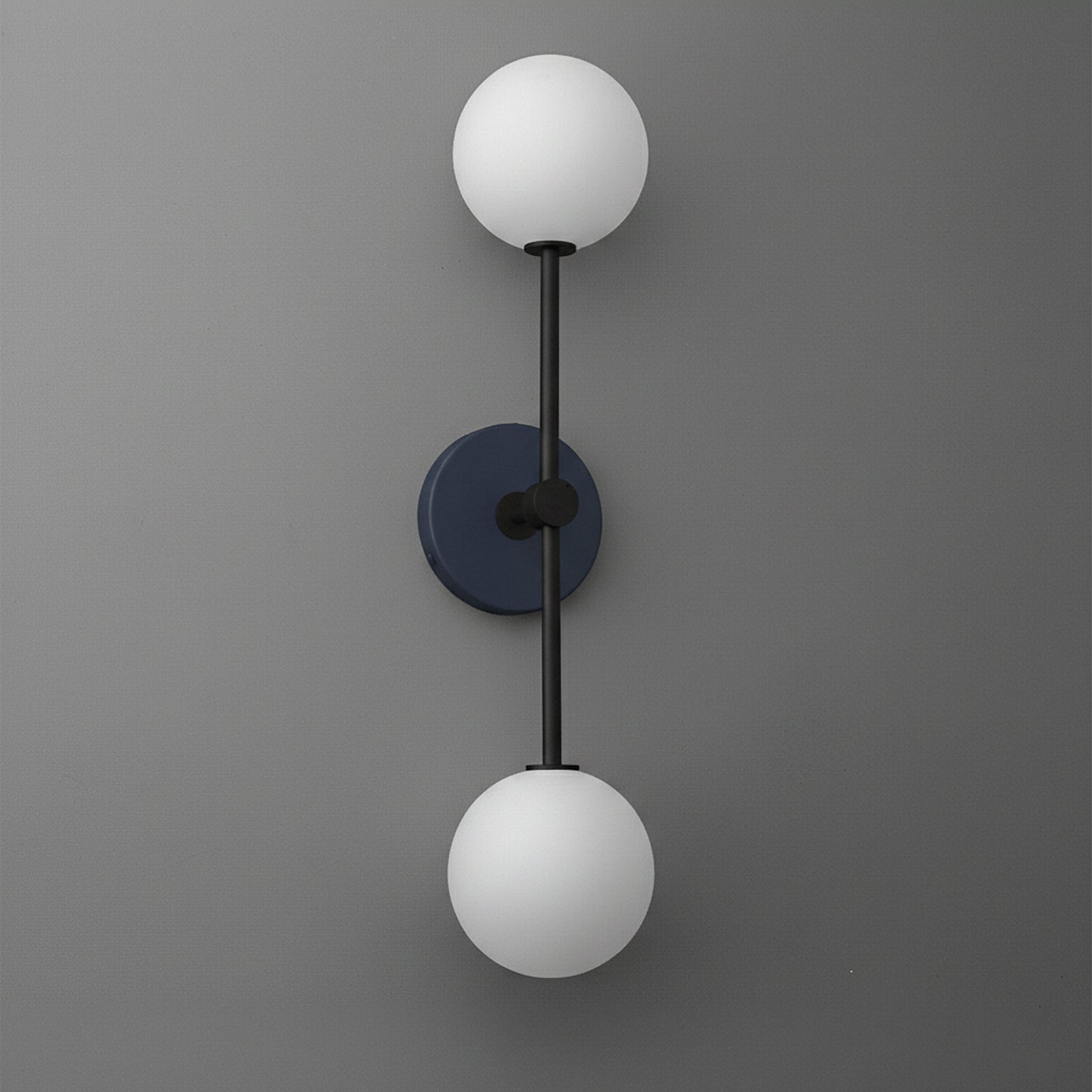 Black metal sconce with two frosted white glass globe shades mounted vertically on a gray wall. - SCONCE MODEL NO. 9776