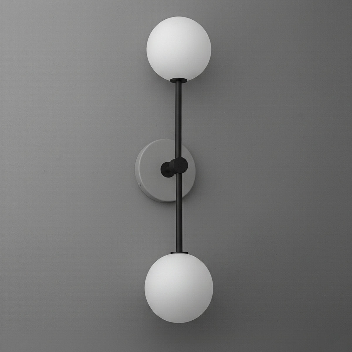 Wall sconce with double white frosted glass globes and matte black vertical metal frame on gray wall. - SCONCE MODEL NO. 9776