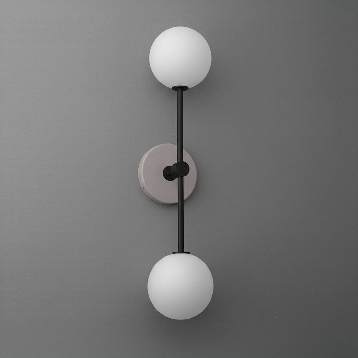 Modern dual-globe wall sconce with matte black metal rod and mauve circular backplate on gray wall. - SCONCE MODEL NO. 9776
