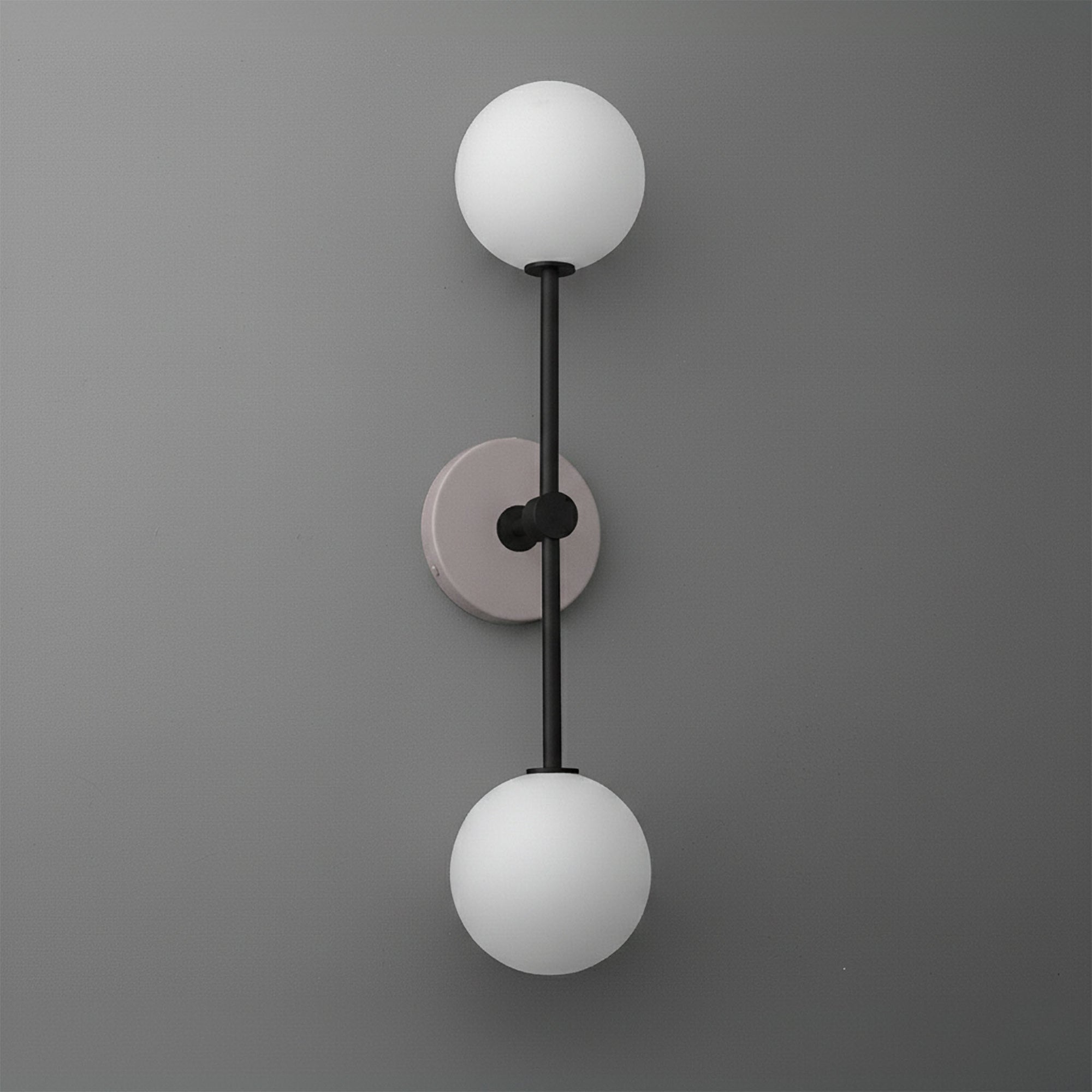 Modern dual-globe wall sconce with matte black metal rod and mauve circular backplate on gray wall. - SCONCE MODEL NO. 9776
