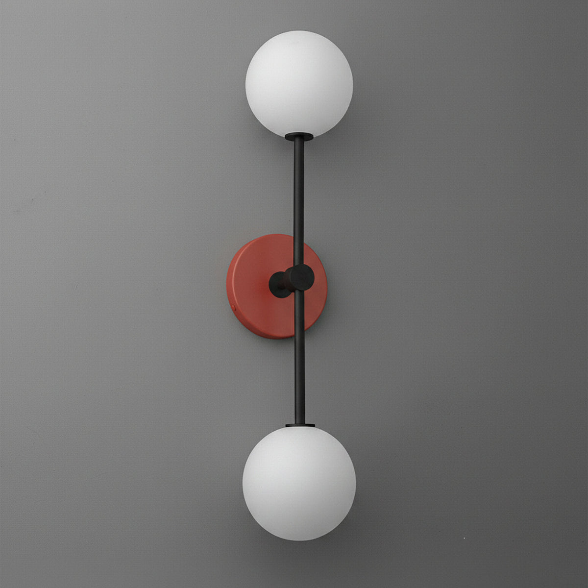 Double globe wall sconce with black metal rod and brick red circular base on gray background. - SCONCE MODEL NO. 9776