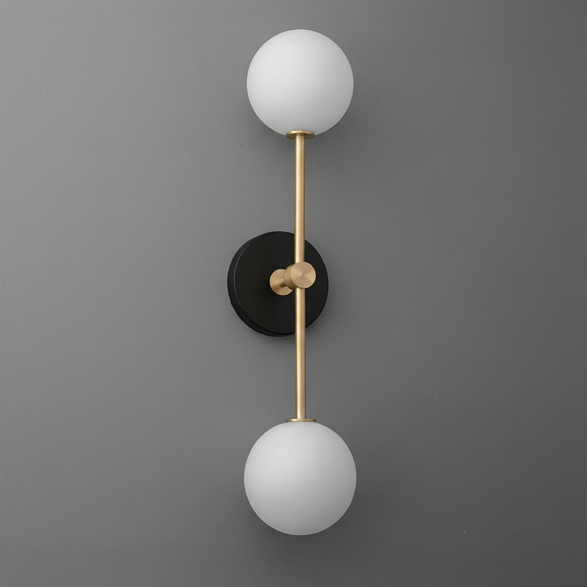 Wall sconce with black round base, vertical brass rod, and two white frosted glass globes. - SCONCE MODEL NO. 9776
