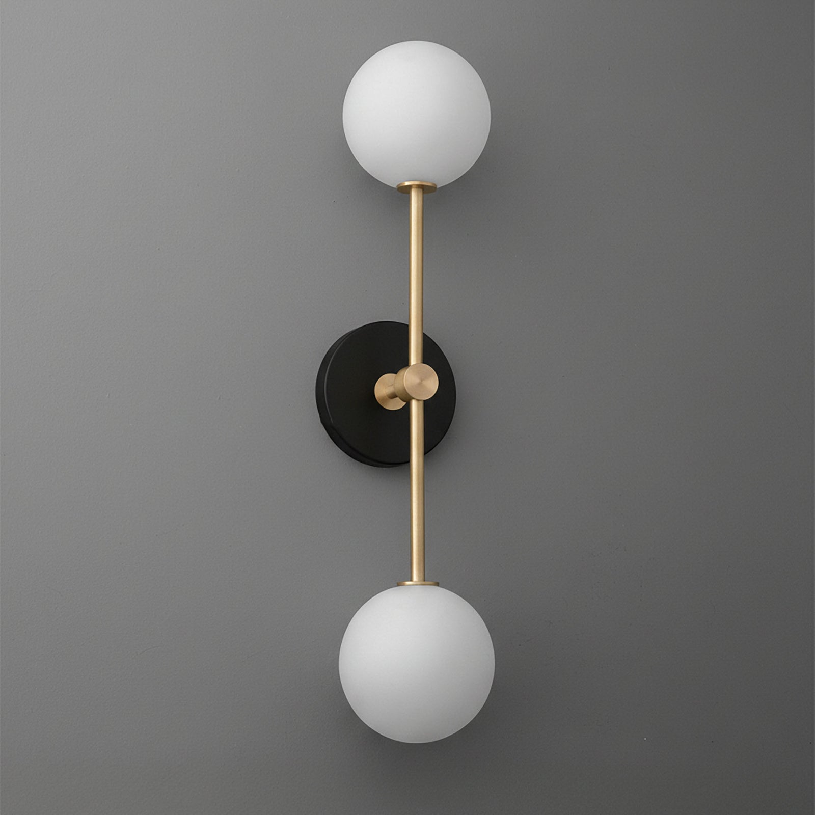 Wall sconce with black round base, vertical brass rod, and two white frosted glass globes. - SCONCE MODEL NO. 9776