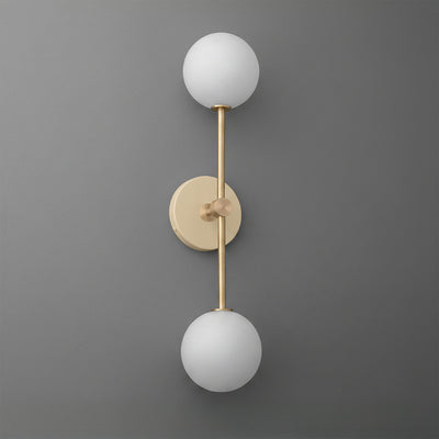 Wall sconce with raw brass finish and two white frosted glass globes on a gray background. - SCONCE MODEL NO. 9776