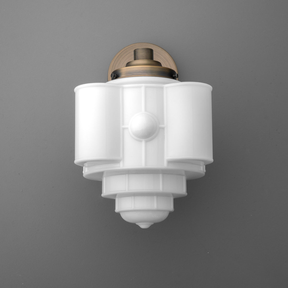 Art Deco white frosted glass sconce with stepped geometric design and brass wall mount. - SCONCE MODEL NO. 1064