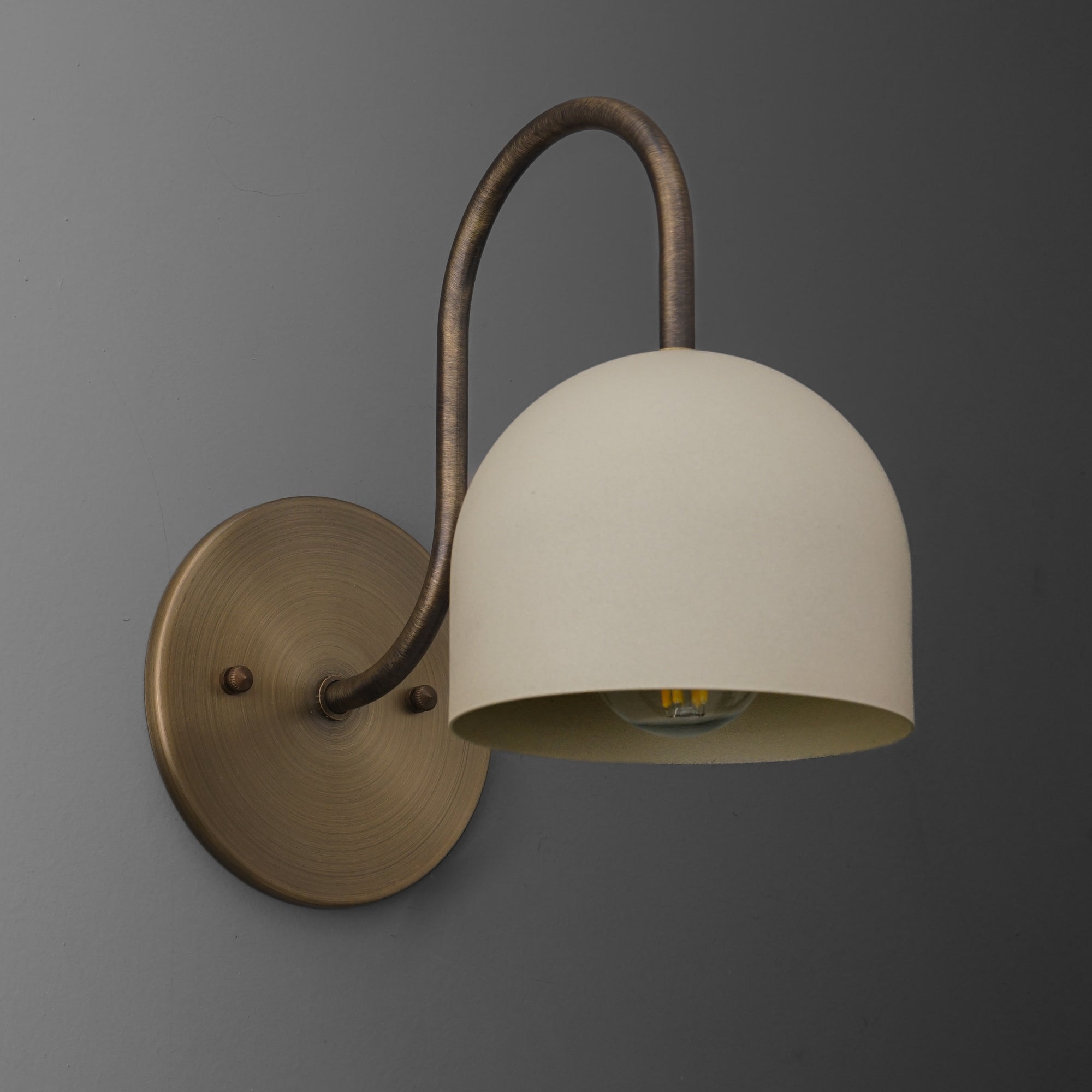 Antique brass wall sconce with curved arm and smooth cream dome shade. - SCONCE MODEL NO. 6308