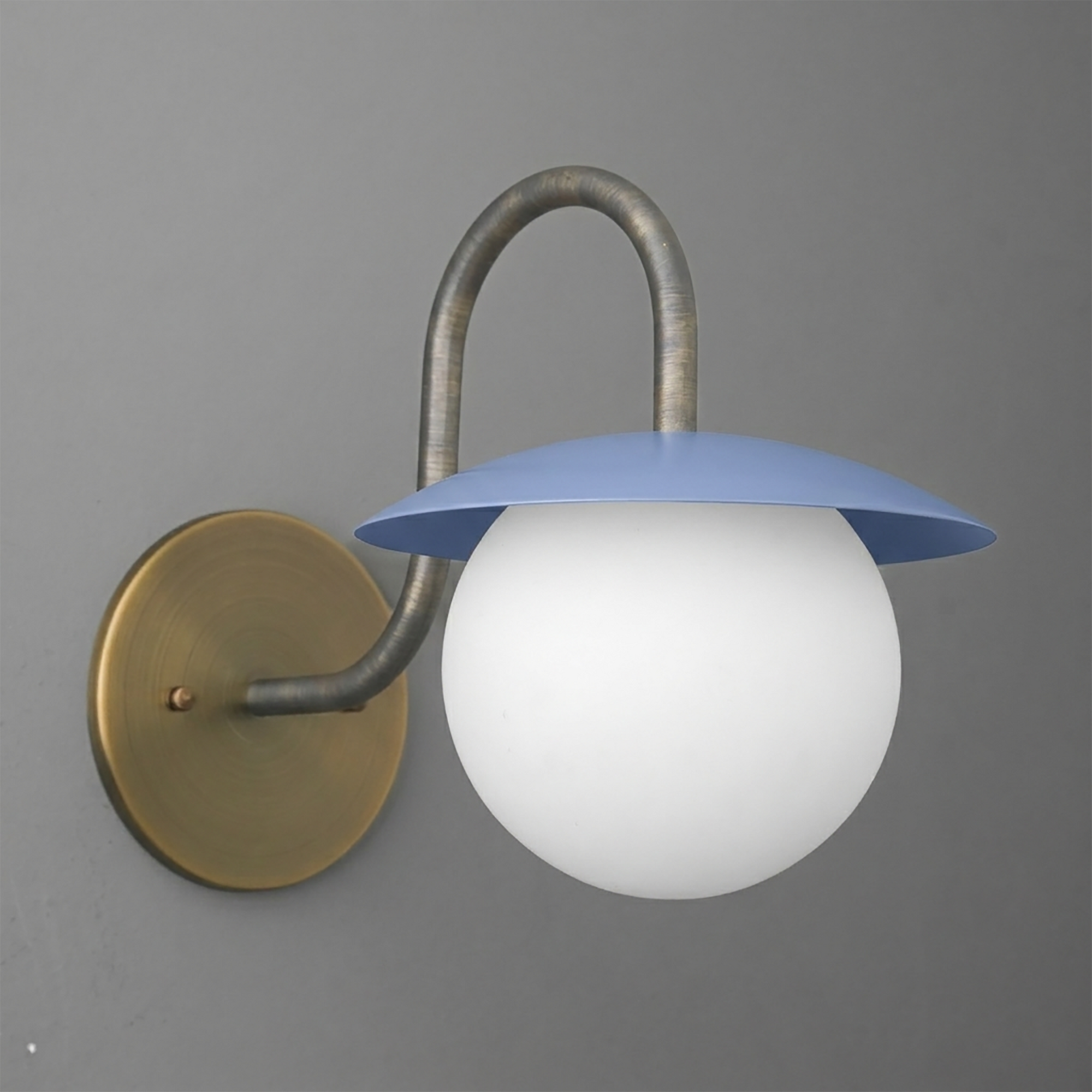 Wall sconce with a round brass base, curved metal arm, and blue metal shade over a white glass globe bulb. - SCONCE MODEL NO. 2206