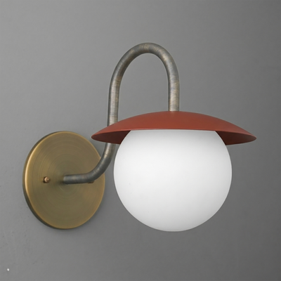 Wall sconce with brass round base, curved metal arm, and frosted white globe shade topped by a rust-red metal cap. - SCONCE MODEL NO. 2206