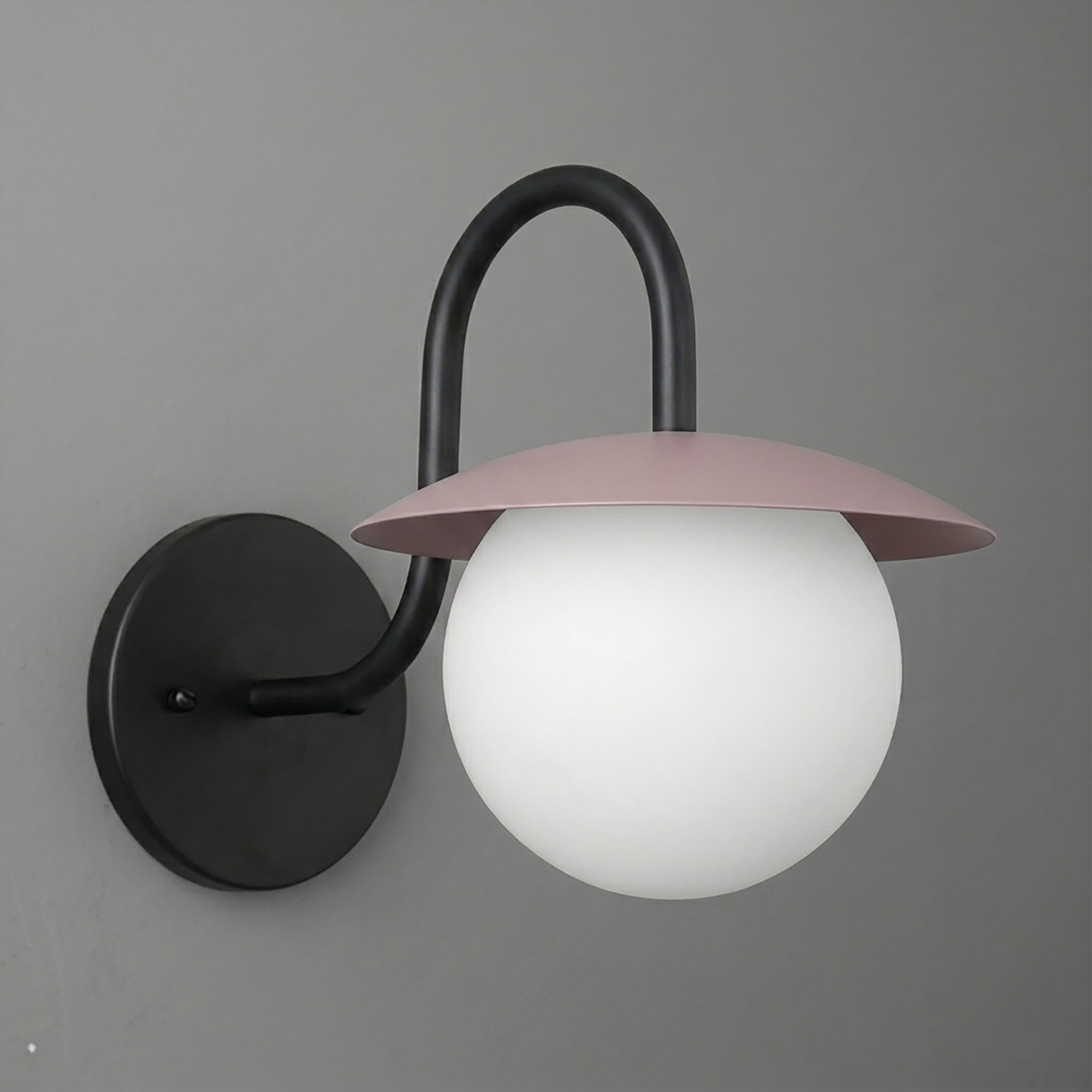 Wall sconce with black curved arm, round black base, and frosted white globe shade topped by pink metal cap. - SCONCE MODEL NO. 2206