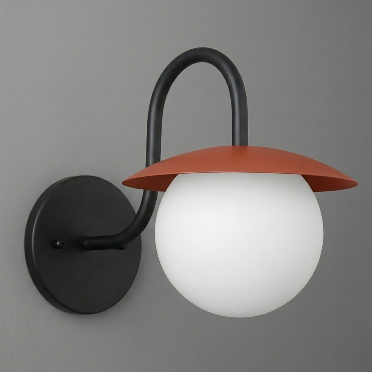 Wall sconce with matte black metal base and curved arm, featuring a frosted white glass globe and rust-colored flat metal. - SCONCE MODEL NO. 2206