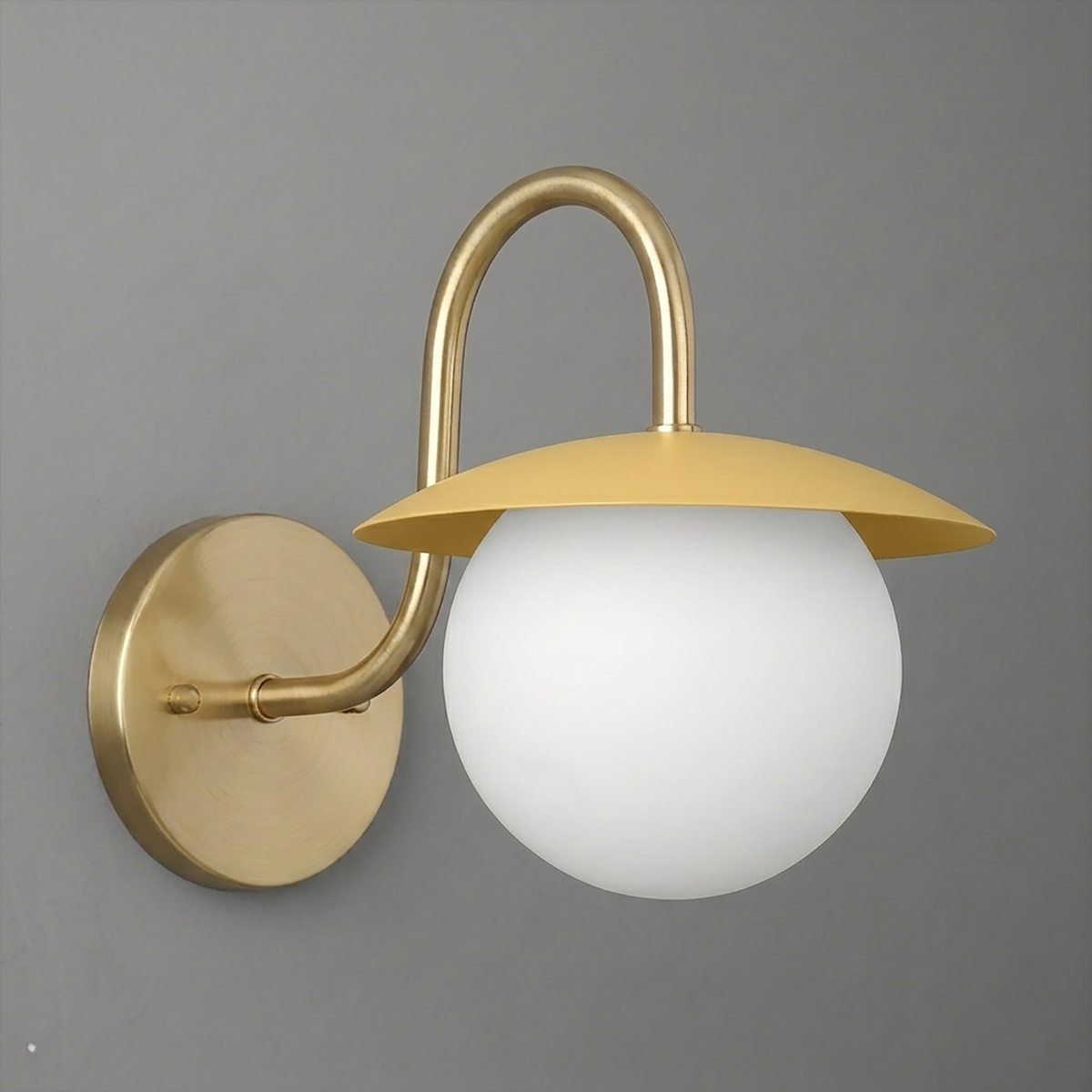 Matte gold wall sconce with round white glass globe and curved arm mounting on circular base. - SCONCE MODEL NO. 2206