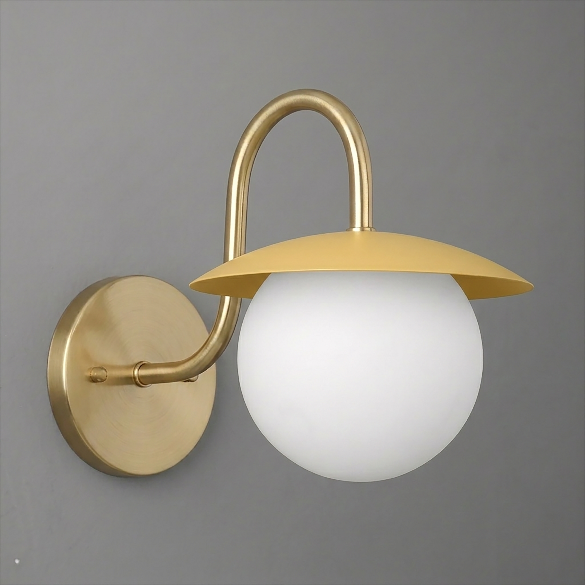 Matte gold wall sconce with round white glass globe and curved arm mounting on circular base. - SCONCE MODEL NO. 2206
