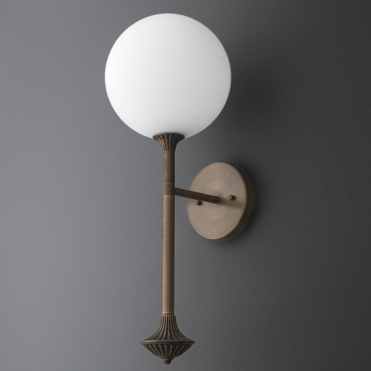 Wall sconce with a round white glass globe and a textured bronze metal arm and base. - SCONCE MODEL NO. 1059