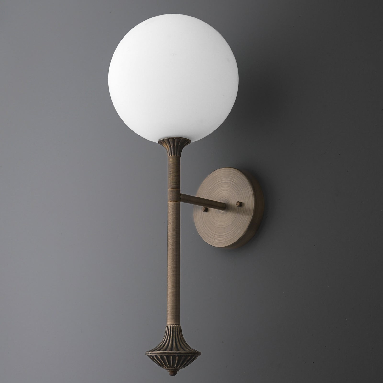 Wall sconce with a round white glass globe and a textured bronze metal arm and base. - SCONCE MODEL NO. 1059