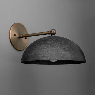 Wall sconce with matte black domed shade and antique brass arm and mounting plate against gray background. - SCONCE MODEL NO. 3164