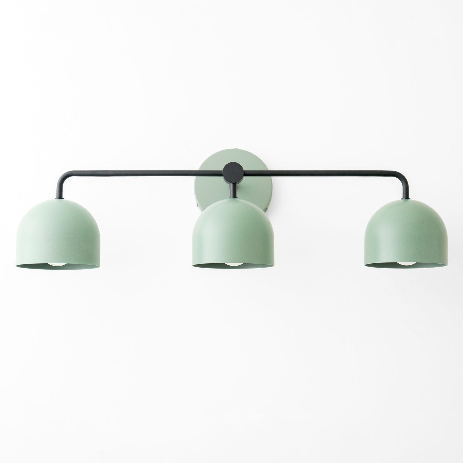 Matte sage green vanity light with three dome-shaped metal shades and black horizontal bar. - VANITY LIGHT MODEL NO. 7456
