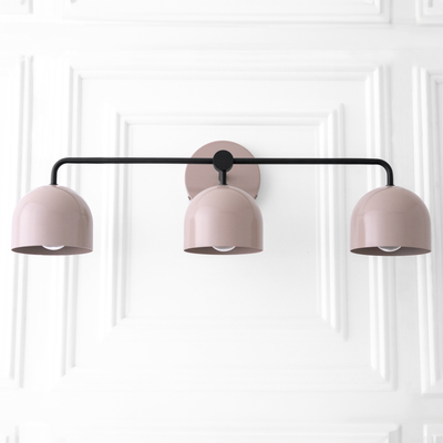 Mid-century modern 3-bulb vanity light with matte mauve dome shades and black metal frame. - VANITY LIGHT MODEL NO. 7456