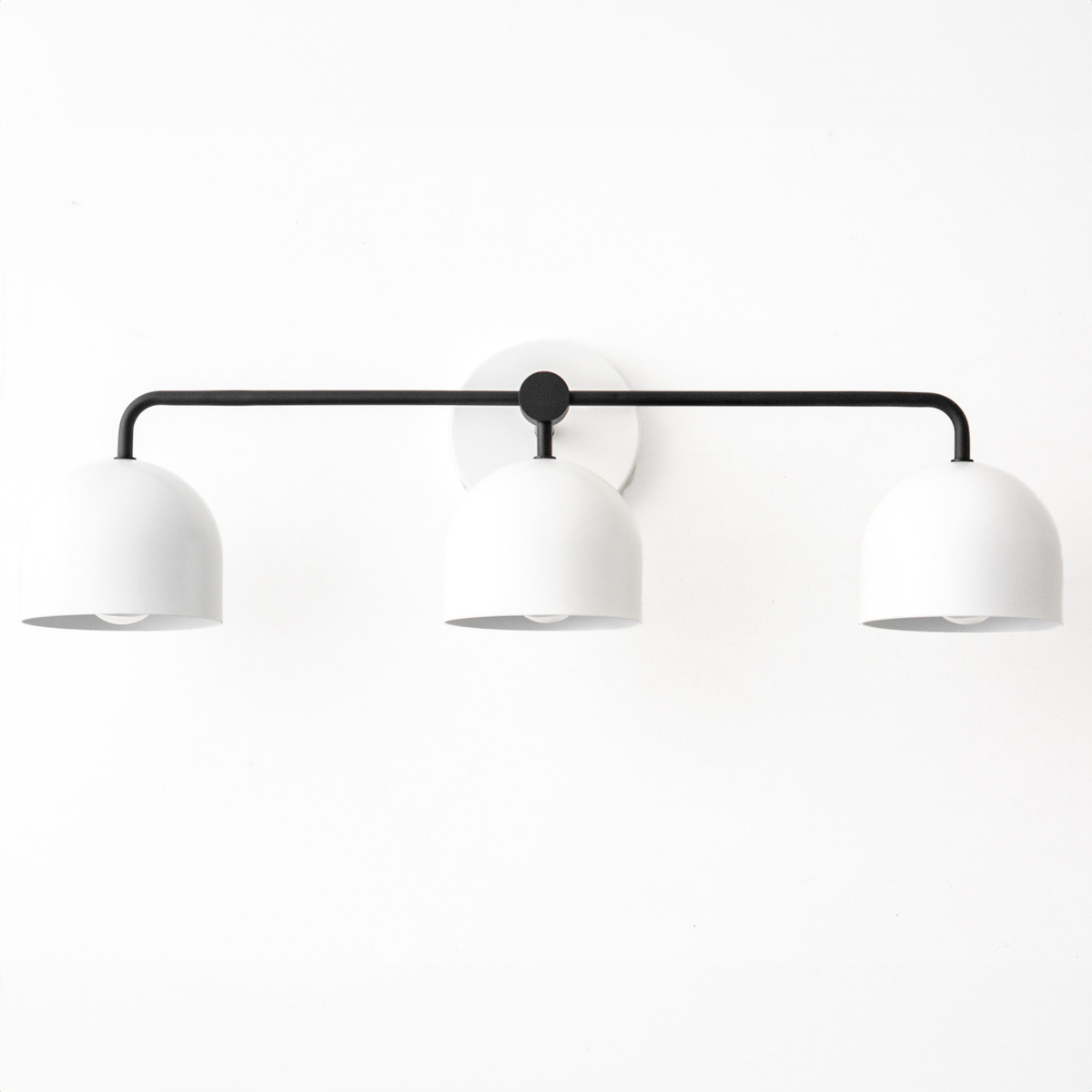 Mid-century modern black vanity light with three white dome-shaped shades and a circular wall mount. - VANITY LIGHT MODEL NO. 7456