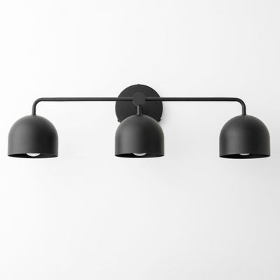 Black metal three-bulb vanity light with dome-shaped shades and a horizontal bar mount. - VANITY LIGHT MODEL NO. 7456