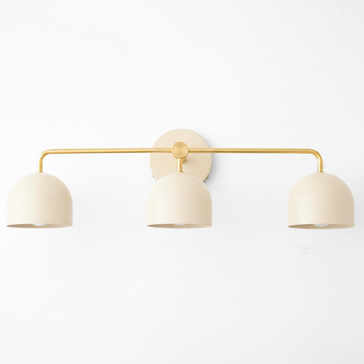 Three-bulb vanity light with matte cream dome shades and brass-finished slender horizontal bar. - VANITY LIGHT MODEL NO. 7456