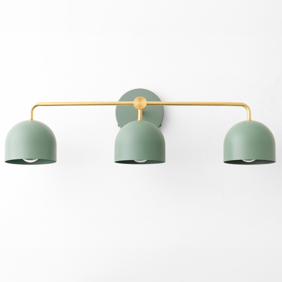 Mid-century modern vanity light with three matte sage green dome shades and brass horizontal bar mount. - VANITY LIGHT MODEL NO. 7456