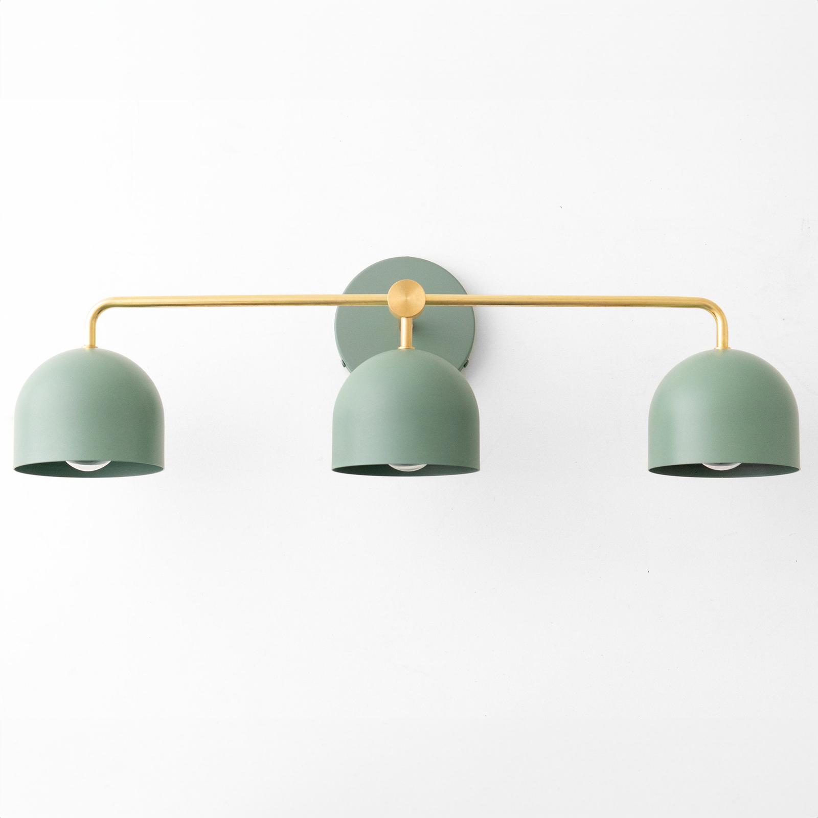 Mid-century modern vanity light with three matte sage green dome shades and brass horizontal bar mount. - VANITY LIGHT MODEL NO. 7456