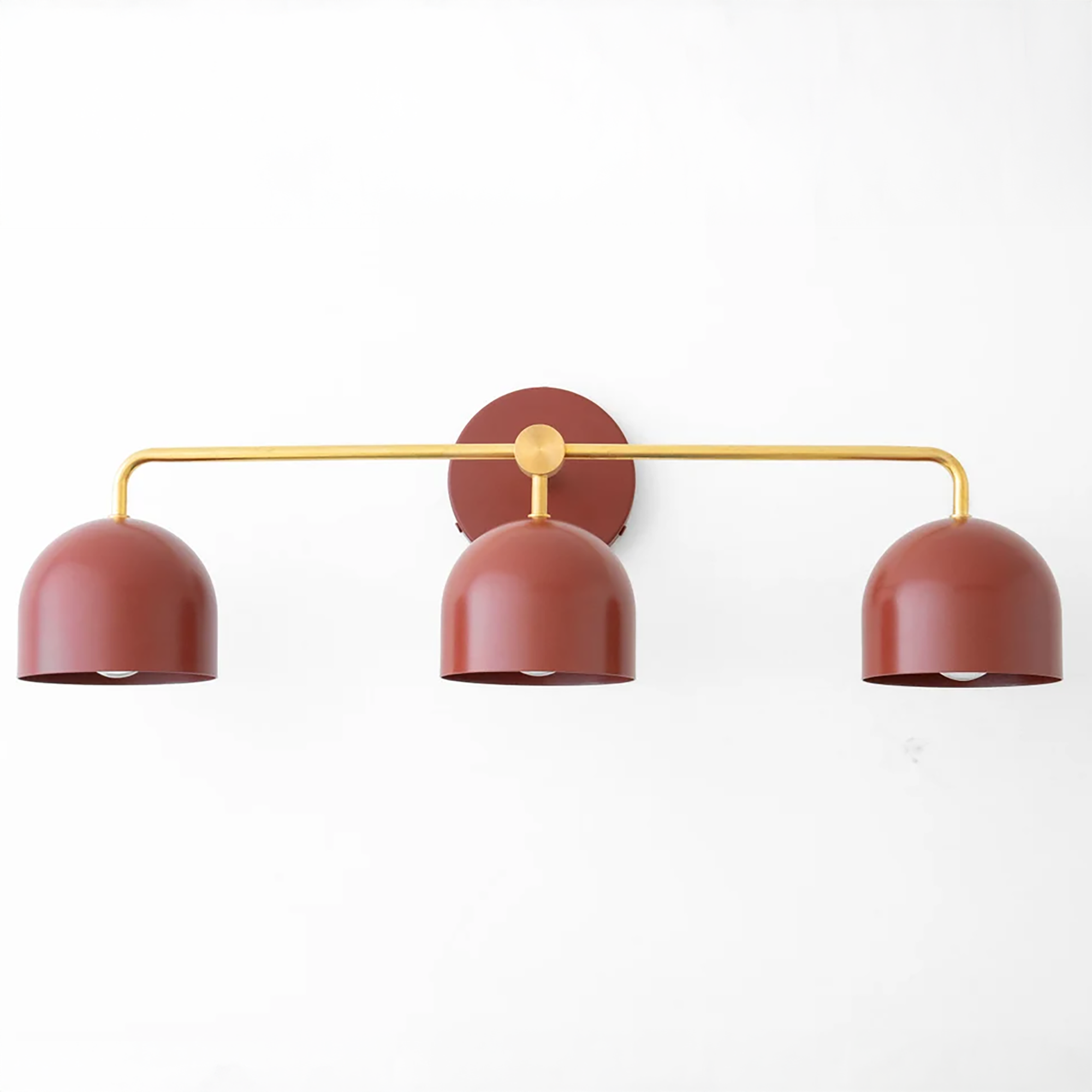 Mid-century modern vanity light with three deep red dome shades on a gold horizontal bar and round wall mount. - VANITY LIGHT MODEL NO. 7456