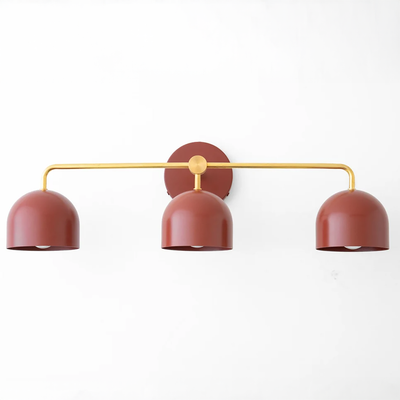 Mid-century modern vanity light with three deep red dome shades on a gold horizontal bar and round wall mount. - VANITY LIGHT MODEL NO. 7456