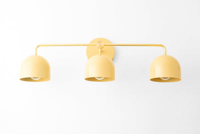 Mid-century modern 3-bulb vanity light with matte yellow dome shades and slim metal frame. - VANITY LIGHT MODEL NO. 7456