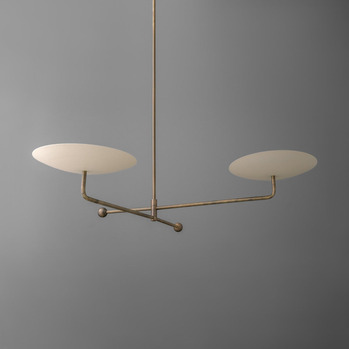 Antique brass chandelier with two cream disc-shaped shades on horizontal arms against gray background. - CHANDELIER MODEL NO. 0680