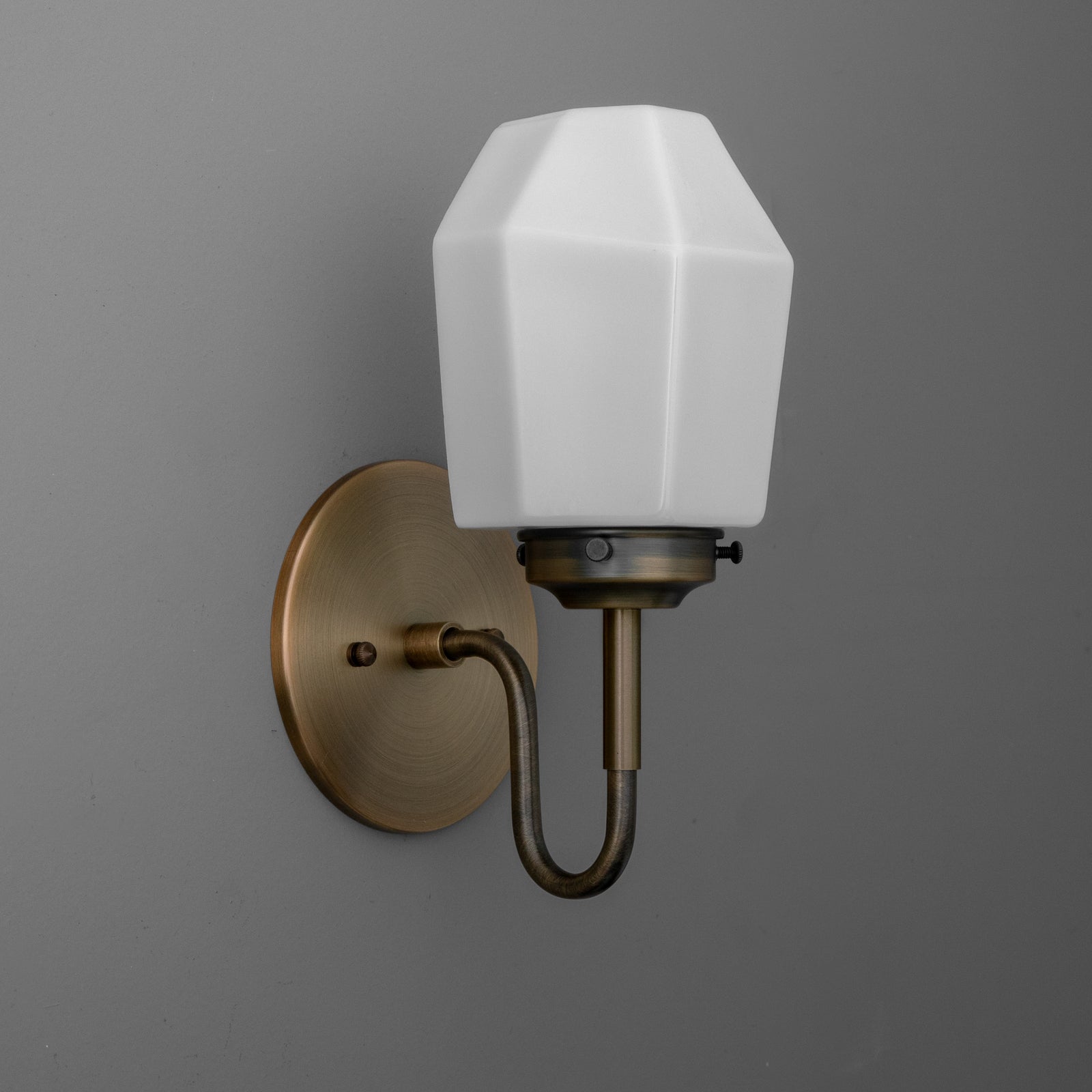 Wall sconce with an antique brass finish and white faceted glass shade, single-bulb design. - SCONCE MODEL NO. 1038