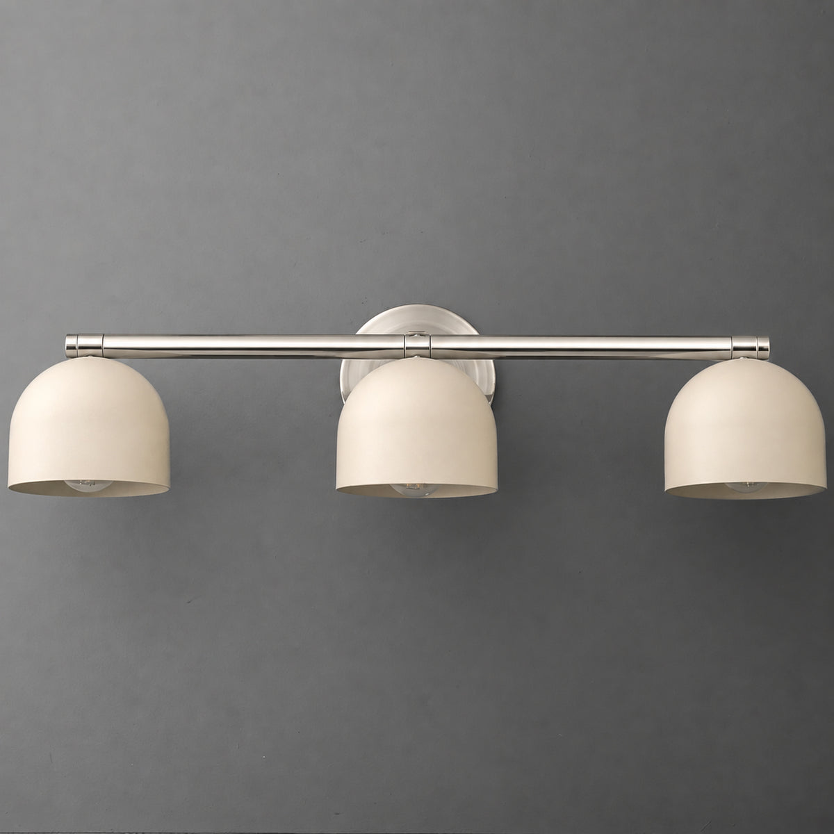 Three-light vanity light in Polished Nickel with Cream dome shades hanging from a long straight bar on a round wall plate. - VANITY LIGHT MODEL NO. 1169