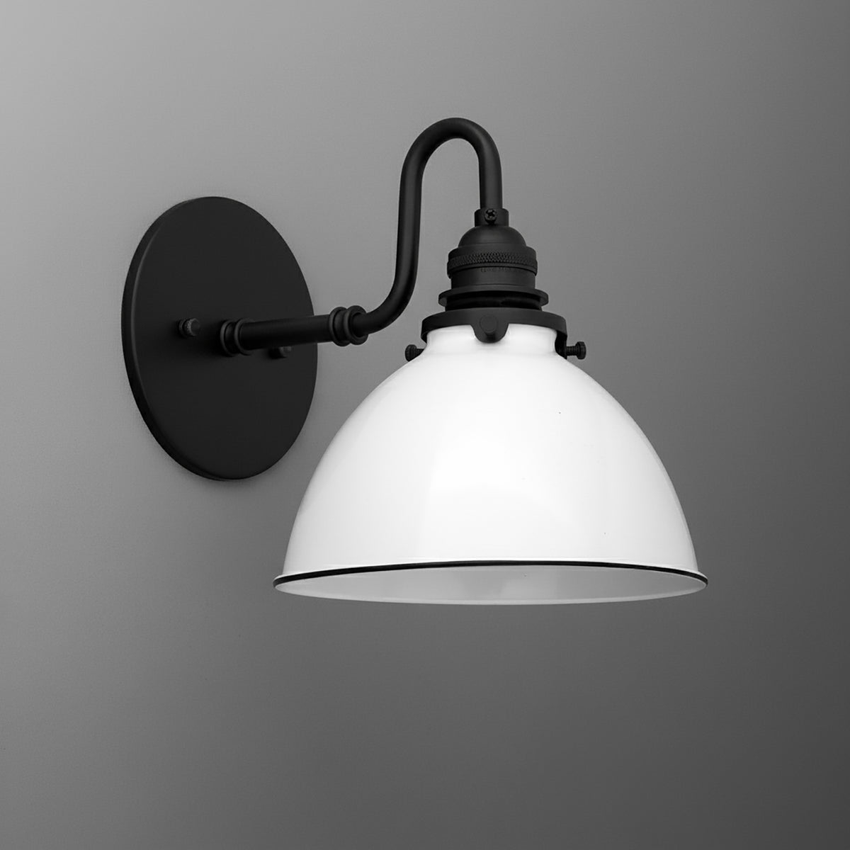 Black metal wall sconce with curved arm and white dome-shaped glass shade. - SCONCE MODEL NO. 2587