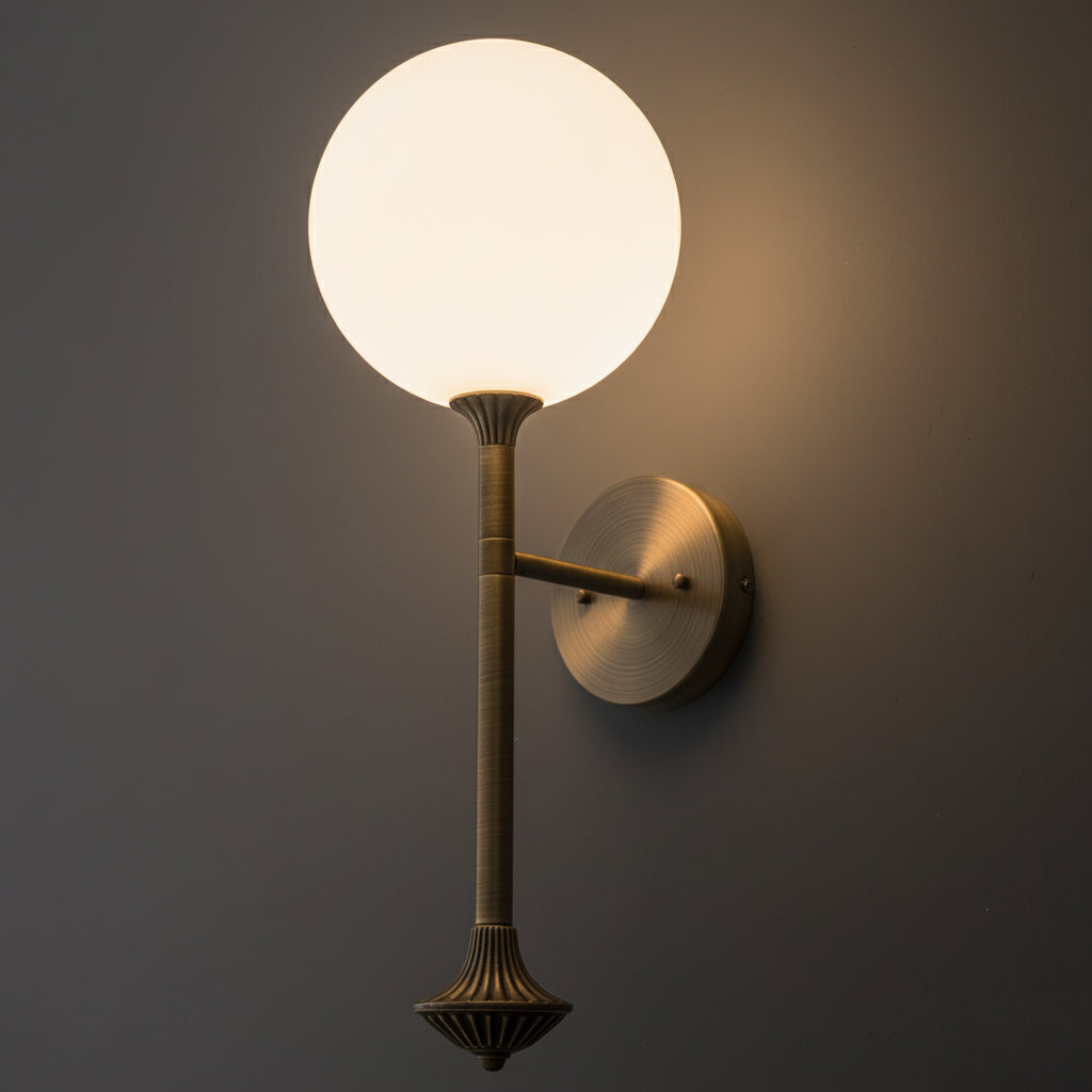 Brass wall sconce with a round white glass globe shade and sculpted decorative base. - SCONCE MODEL NO. 1059