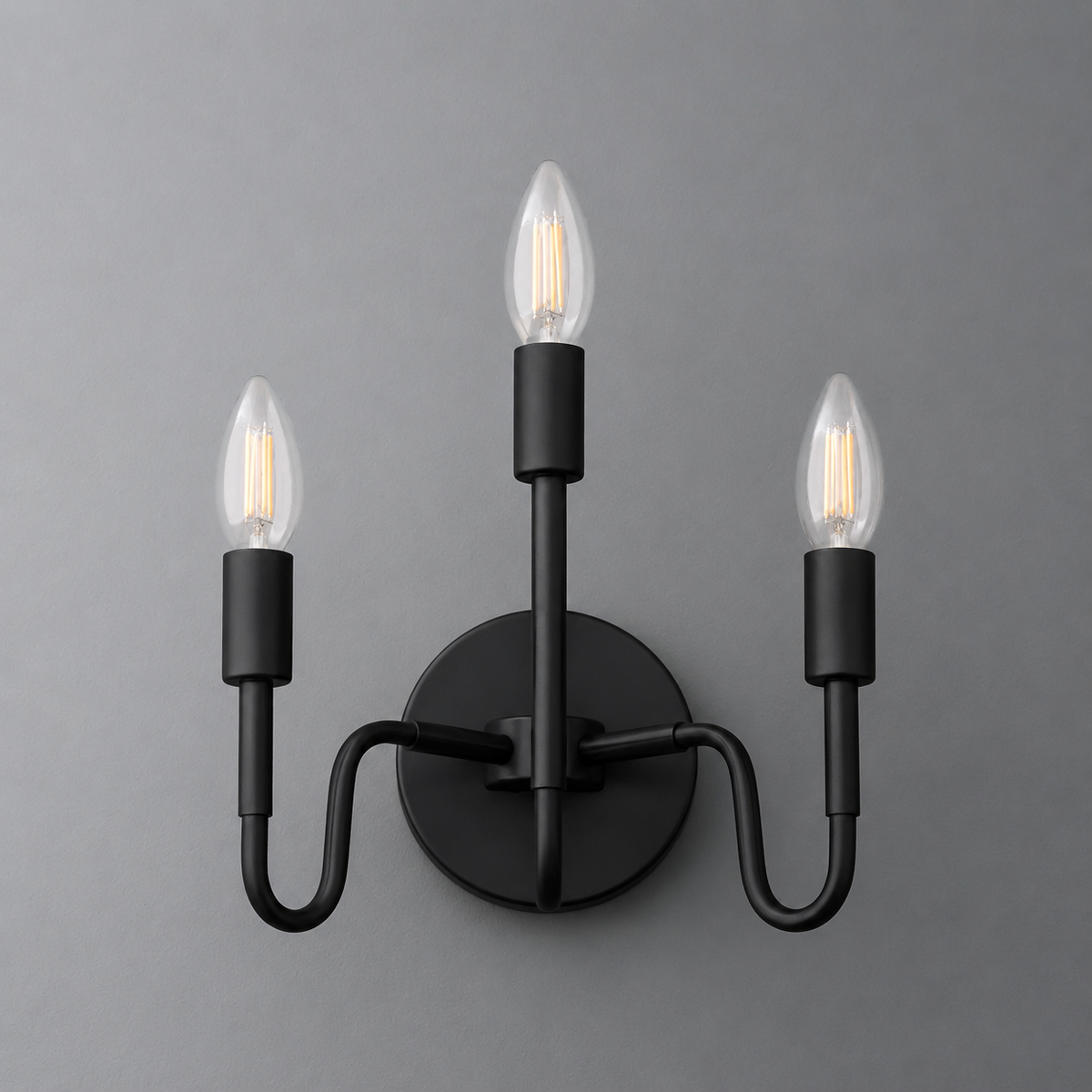 Matte black metal wall sconce with three upward-facing candle-style bulbs and curved arms. - SCONCE MODEL NO. 2943