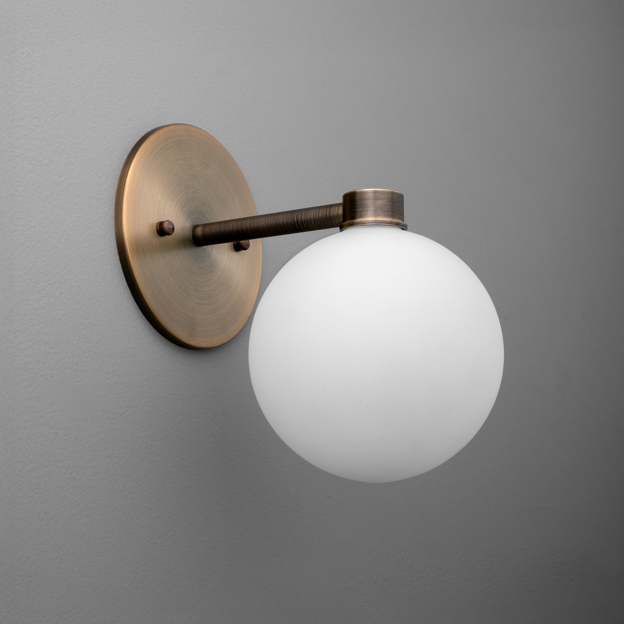 Minimalist wall sconce with antique brass finish and frosted white glass globe shade. - SCONCE MODEL NO. 2341