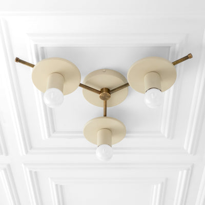 Flush mount chandelier with three cream matte shades and antique brass accents on a white ceiling panel. - CHANDELIER MODEL NO. 9526