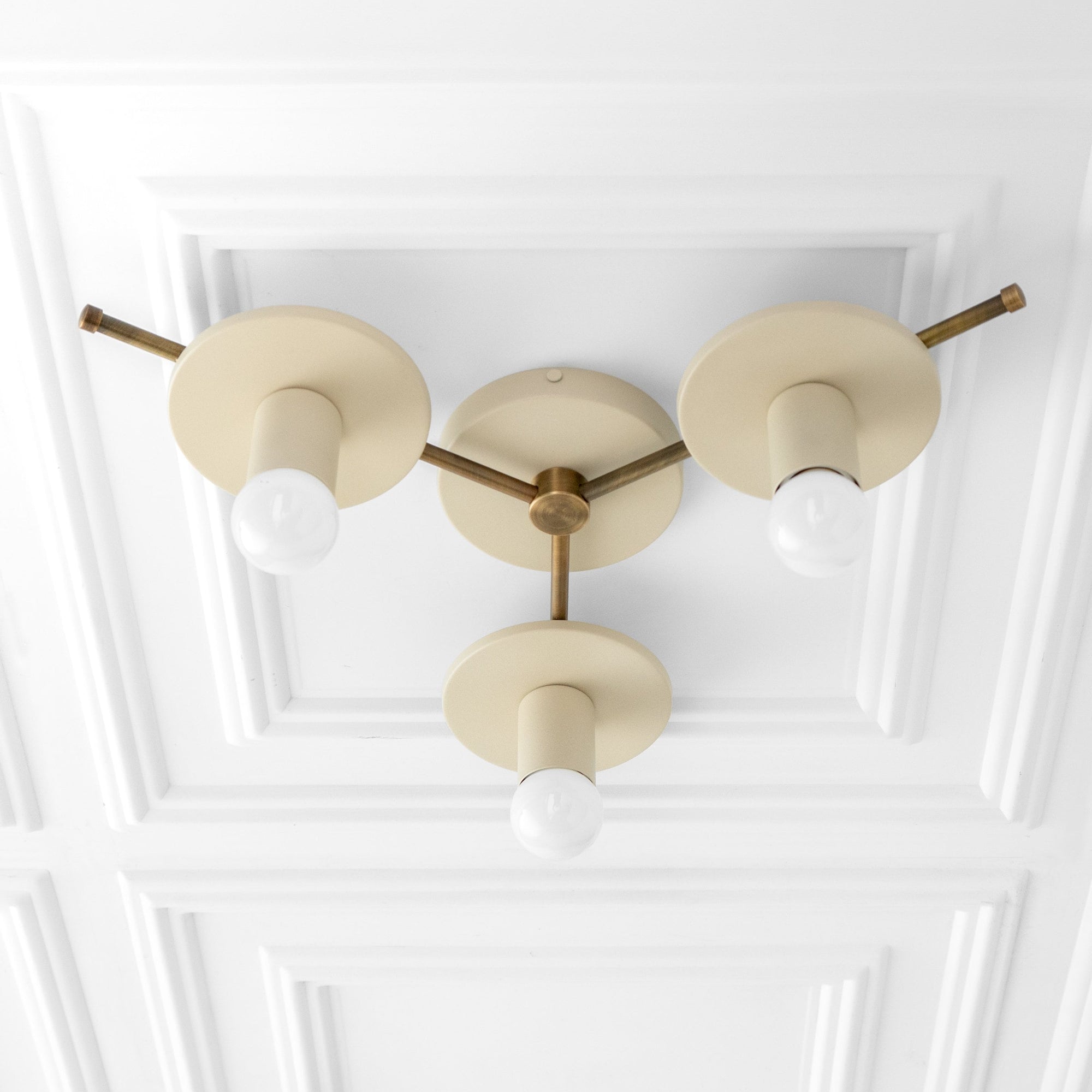 Mid-century modern flush mount ceiling light with three beige circular shades and exposed white bulbs on brass rods. - CHANDELIER MODEL NO. 9526