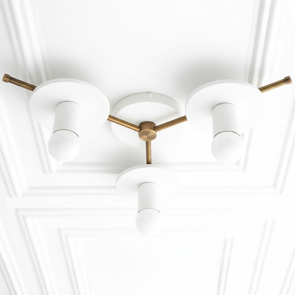 Mid-century modern chandelier with three white cylindrical shades and antique brass arms and base flush mounted on ceiling. - CHANDELIER MODEL NO. 9526