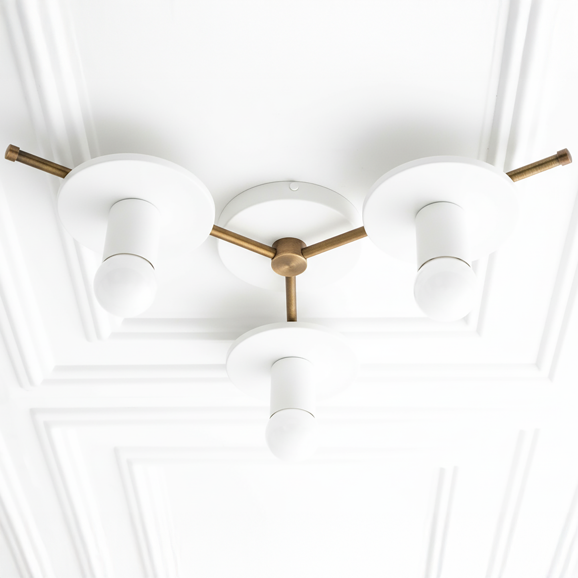 Mid-century modern chandelier with three white cylindrical shades and antique brass arms and base flush mounted on ceiling. - CHANDELIER MODEL NO. 9526