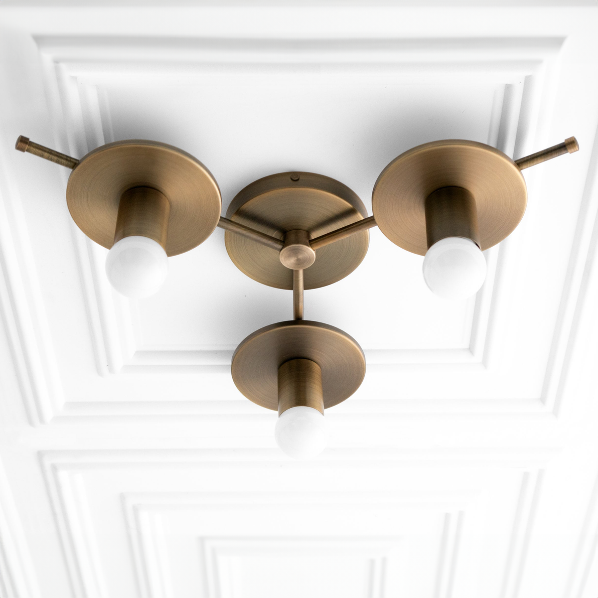 Mid century modern raw brass flush mount chandelier with three exposed white bulbs on textured ceiling panel. - CHANDELIER MODEL NO. 9526