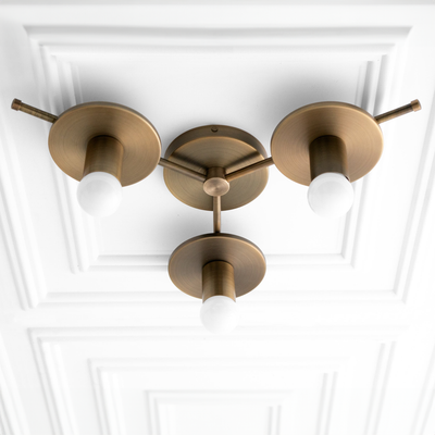 Mid century modern raw brass flush mount chandelier with three exposed white bulbs on textured ceiling panel. - CHANDELIER MODEL NO. 9526