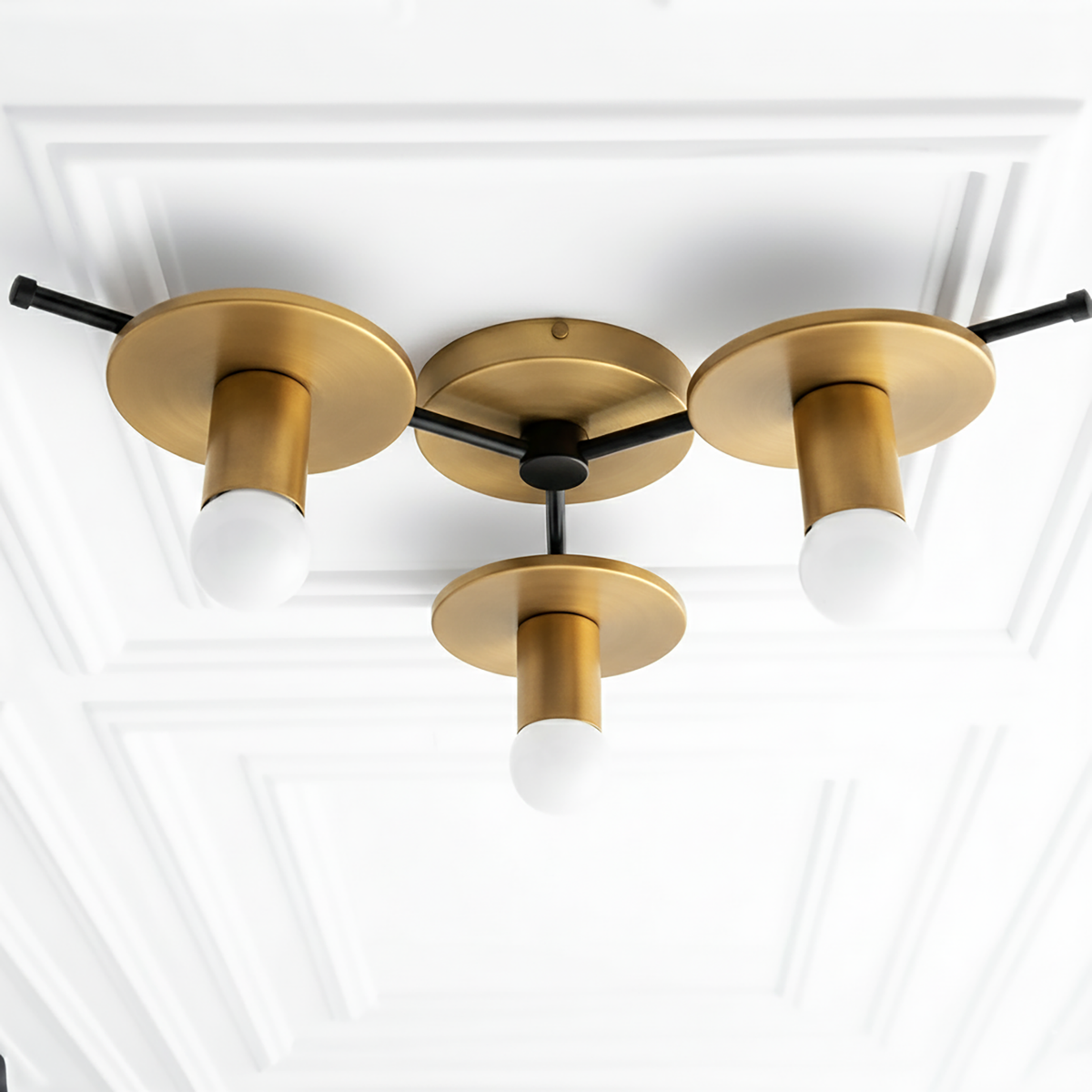 Flush mount chandelier with three raw brass cylindrical shades and white bare bulbs on black connecting rods. - CHANDELIER MODEL NO. 9526