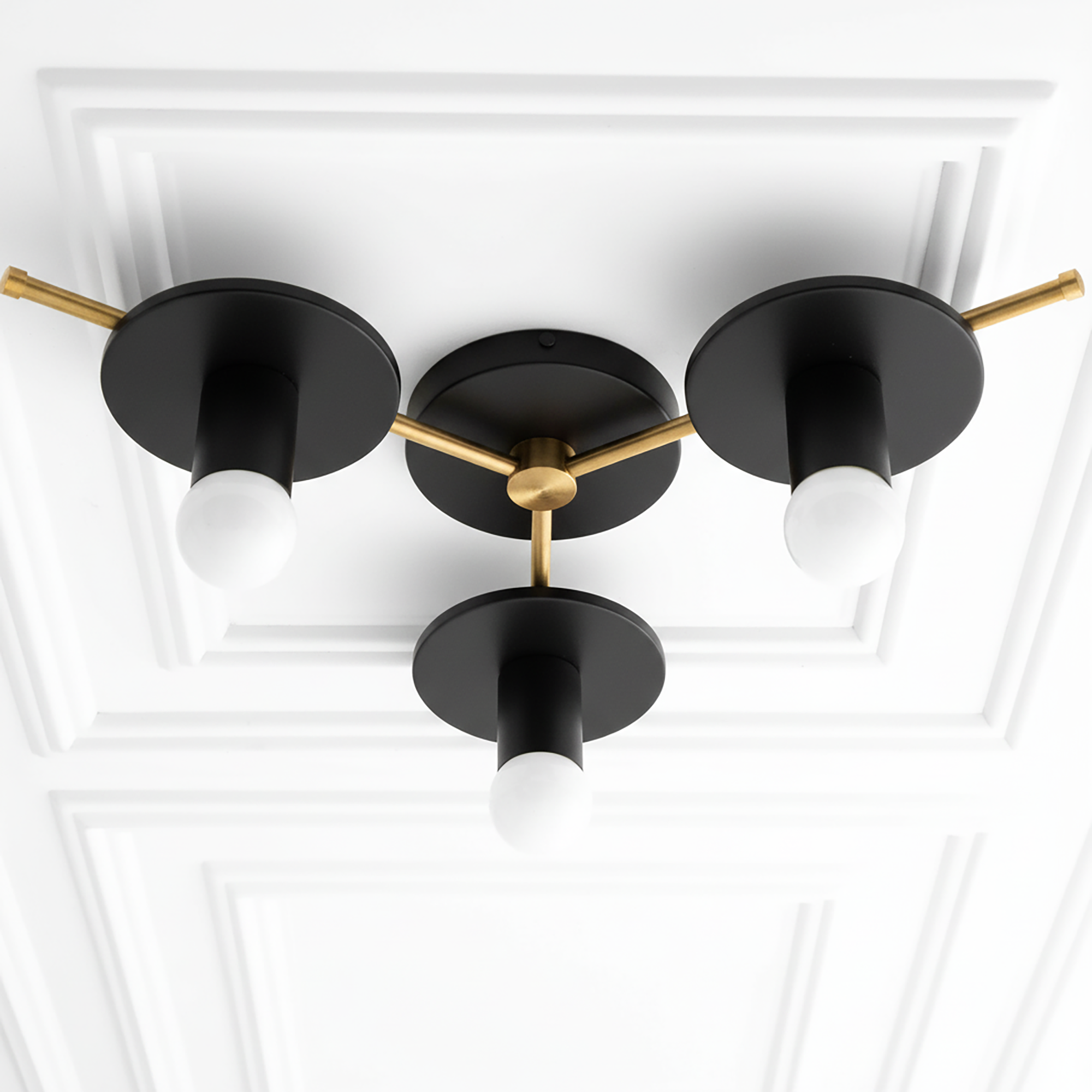 Mid-century modern flush mount chandelier with three exposed white bulbs, black metal shades, and brass accents. - CHANDELIER MODEL NO. 9526