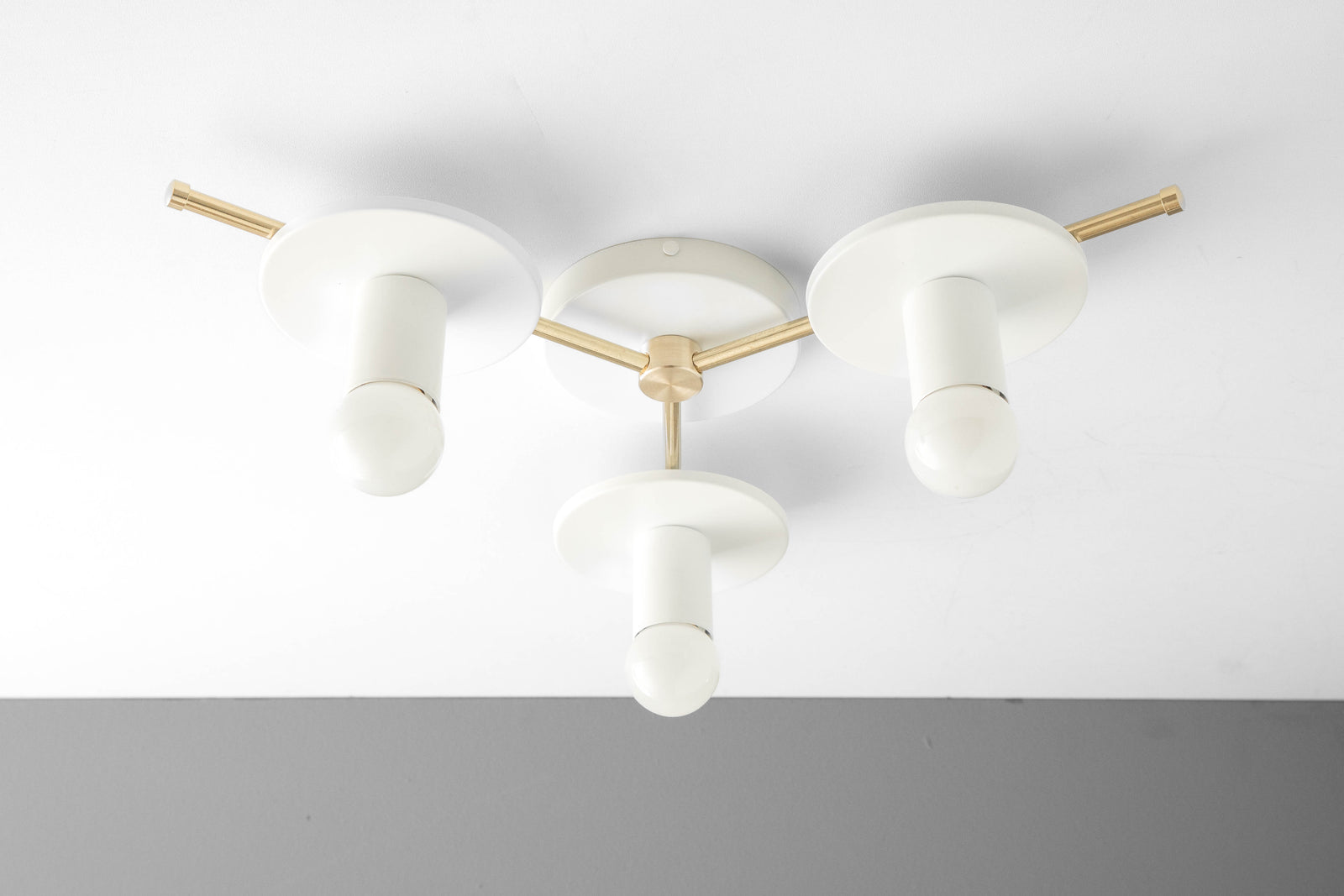 Mid-century modern flush mount ceiling light with three white cylindrical shades and gold metal accents. - CHANDELIER MODEL NO. 9526