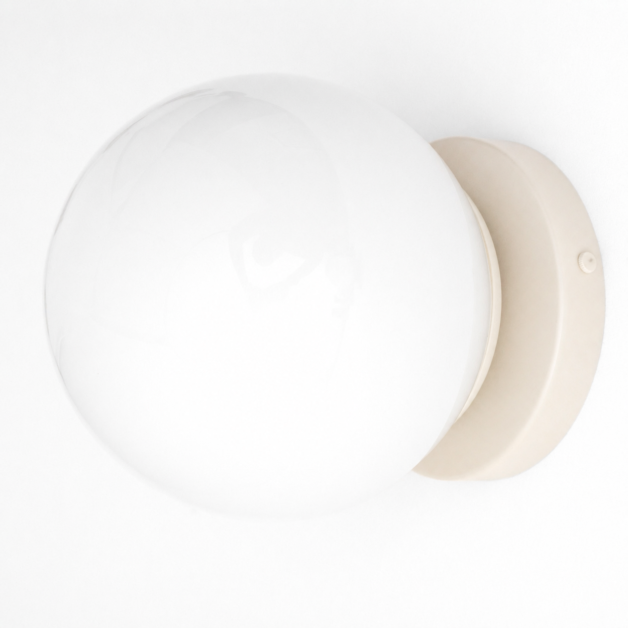 White glass globe wall sconce with beige round flush mount base and mid-century modern design. - SCONCE MODEL NO. 3825