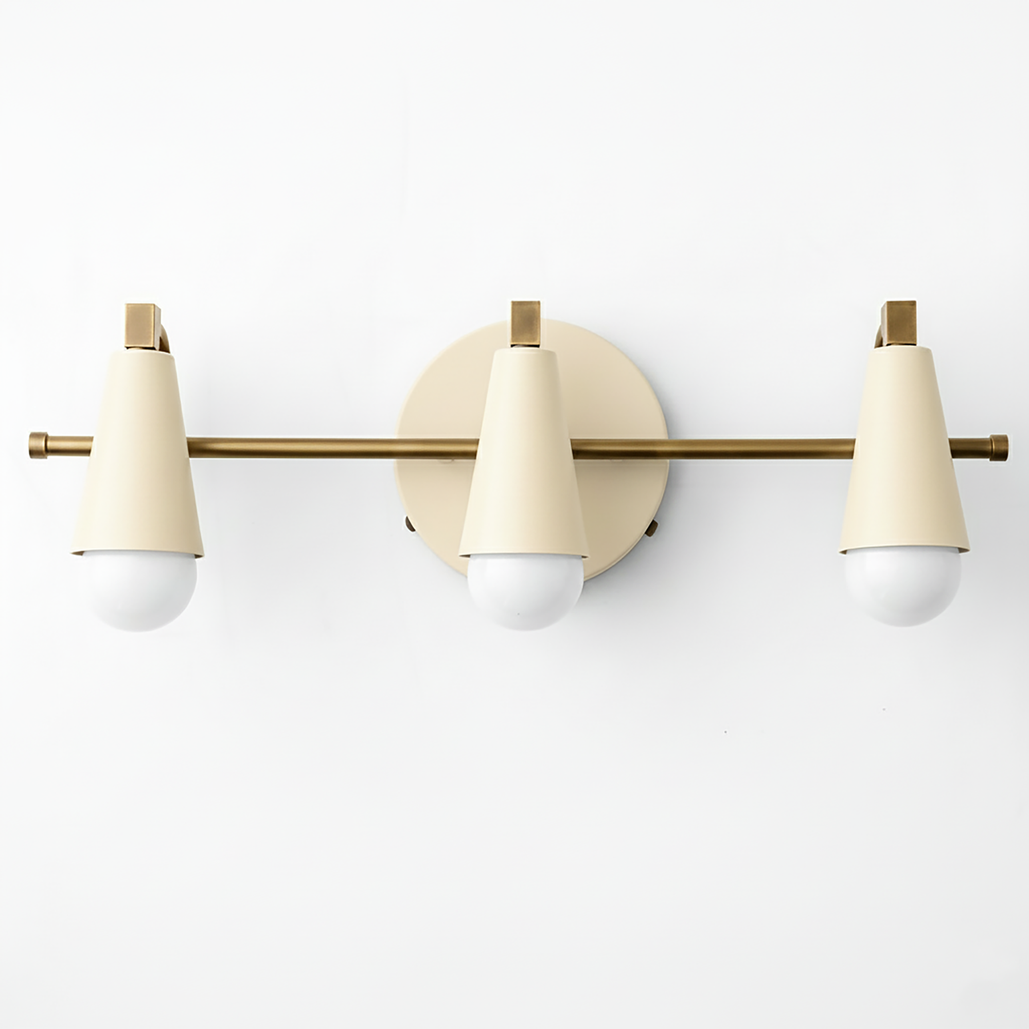 Three-light vanity fixture with matte cream conical shades and brass horizontal bar mounting. - VANITY LIGHT MODEL NO. 8084